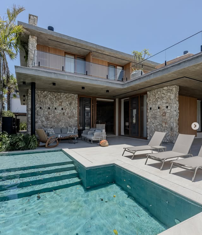 Residência com piscina, pedra natural e concreto aparente